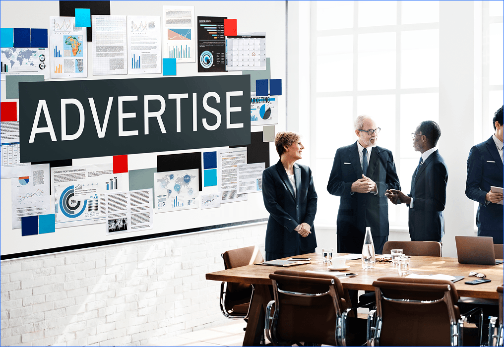 Retail team discussing advertising strategy with data charts and marketing visuals on a board.